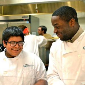 an adult and a child wearing cooking uniforms