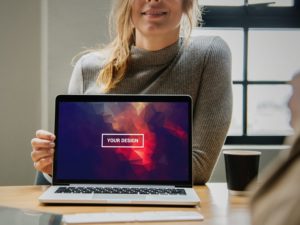 Read more about the article Woman in Office Presenting MacBook Free Mockup