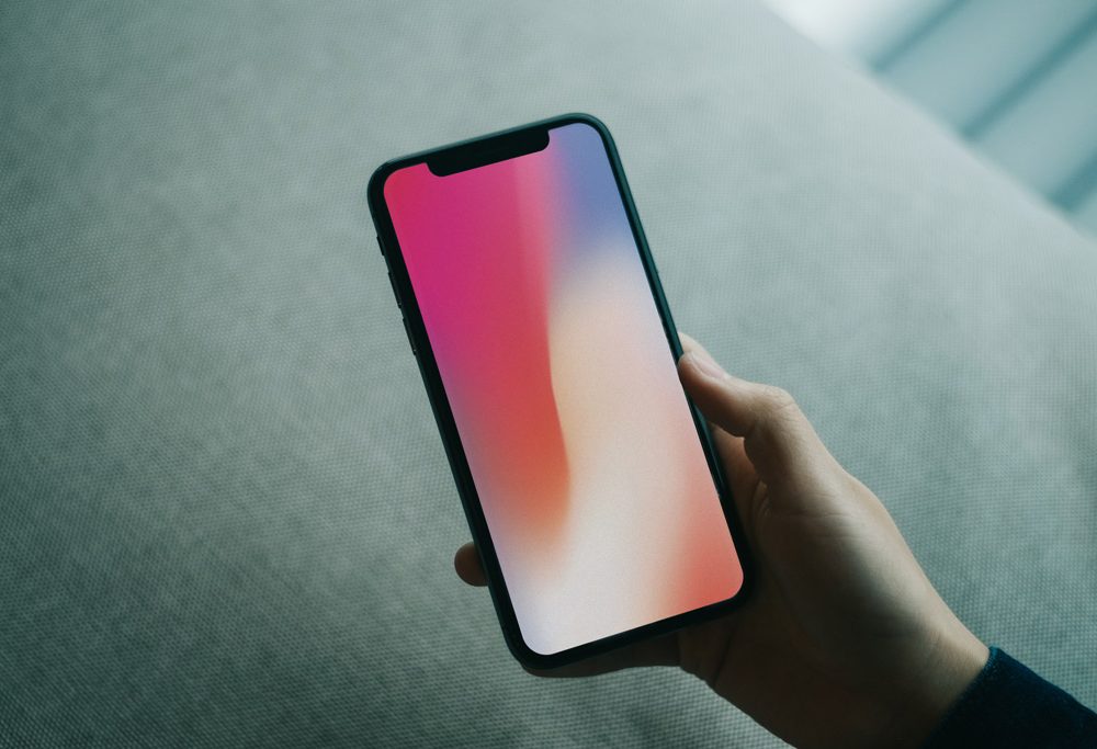 Read more about the article Hand holding iPhone X free PSD